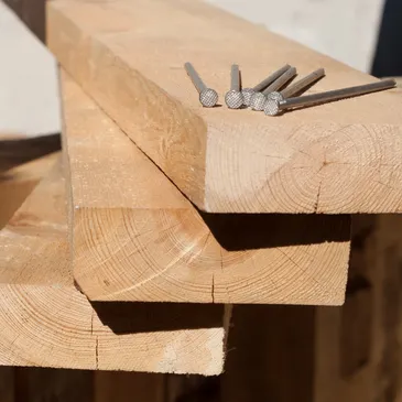 A close up of some wood with nails on top