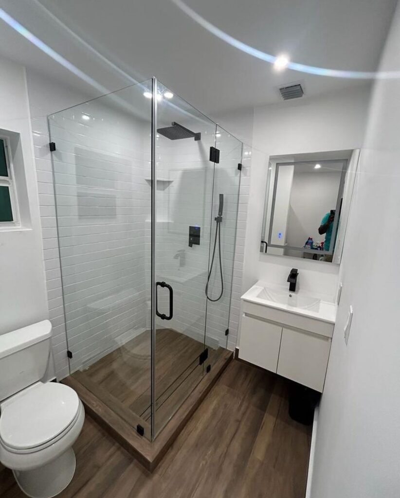 A Glass Cabinet Space With A Shower Head In Place